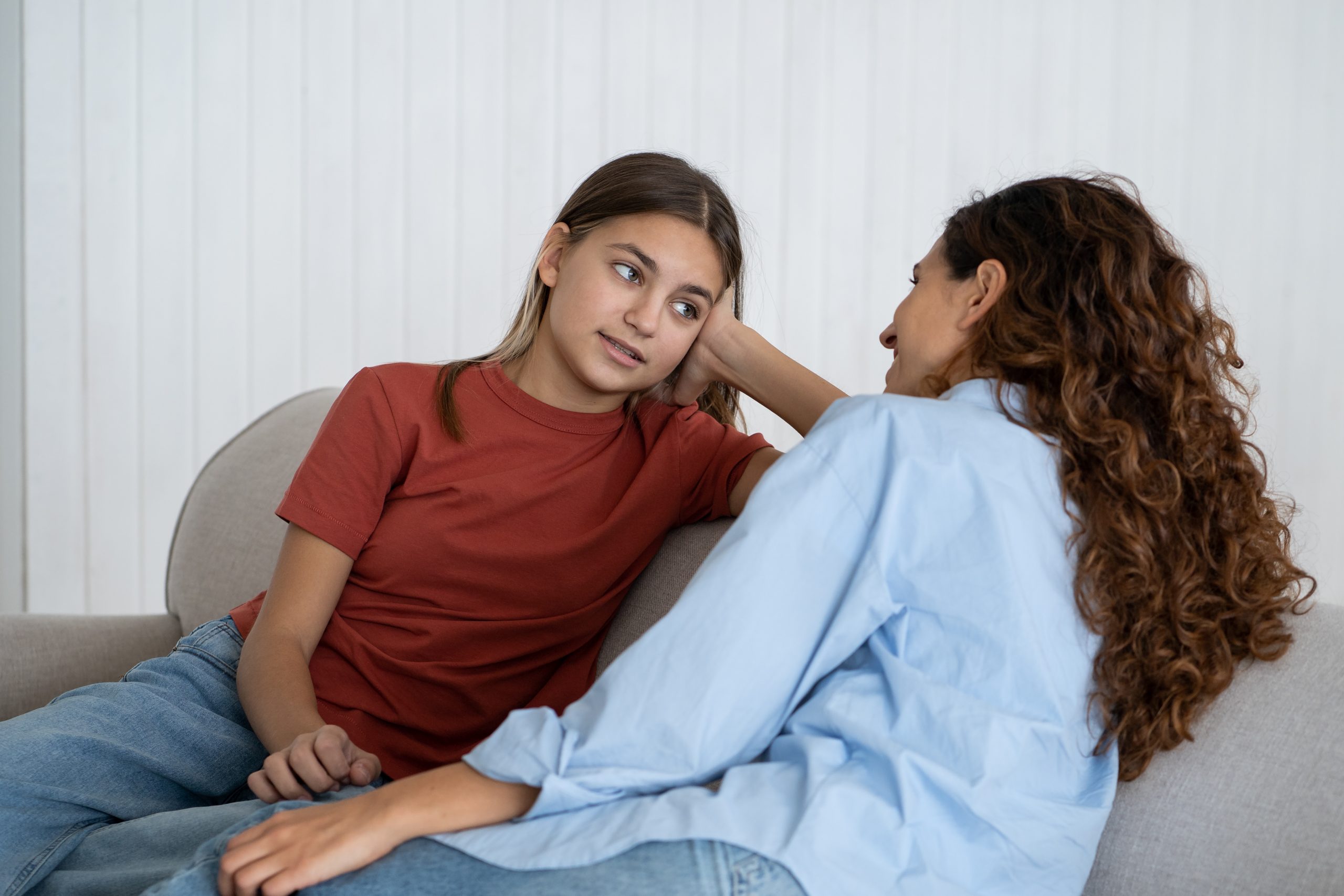 Teenage daughter talking to her mother on the sofa